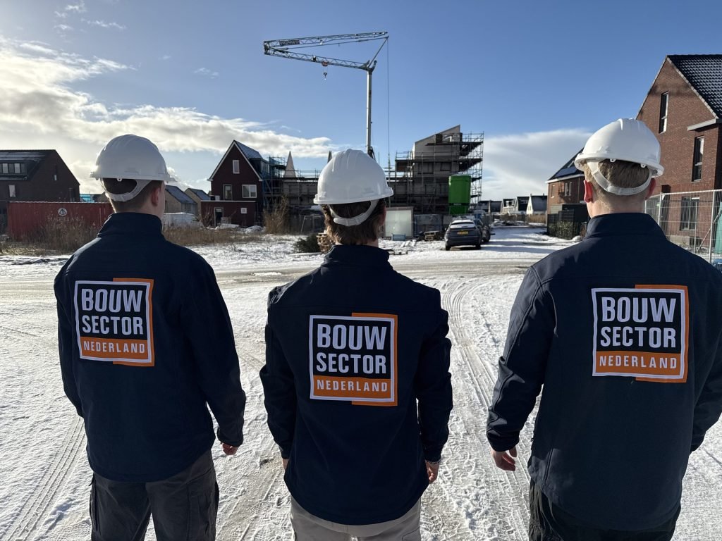 Drie medewerkers van Bouwsector Nederland met witte helm in een nieuwbouwwijk in aanbouw